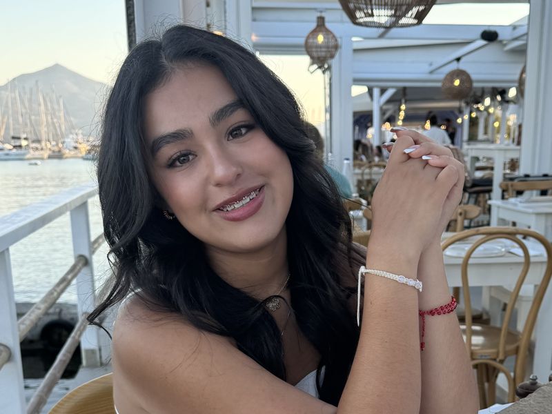 Kylie Carrillo smiling at a seaside café in Milos, Greece